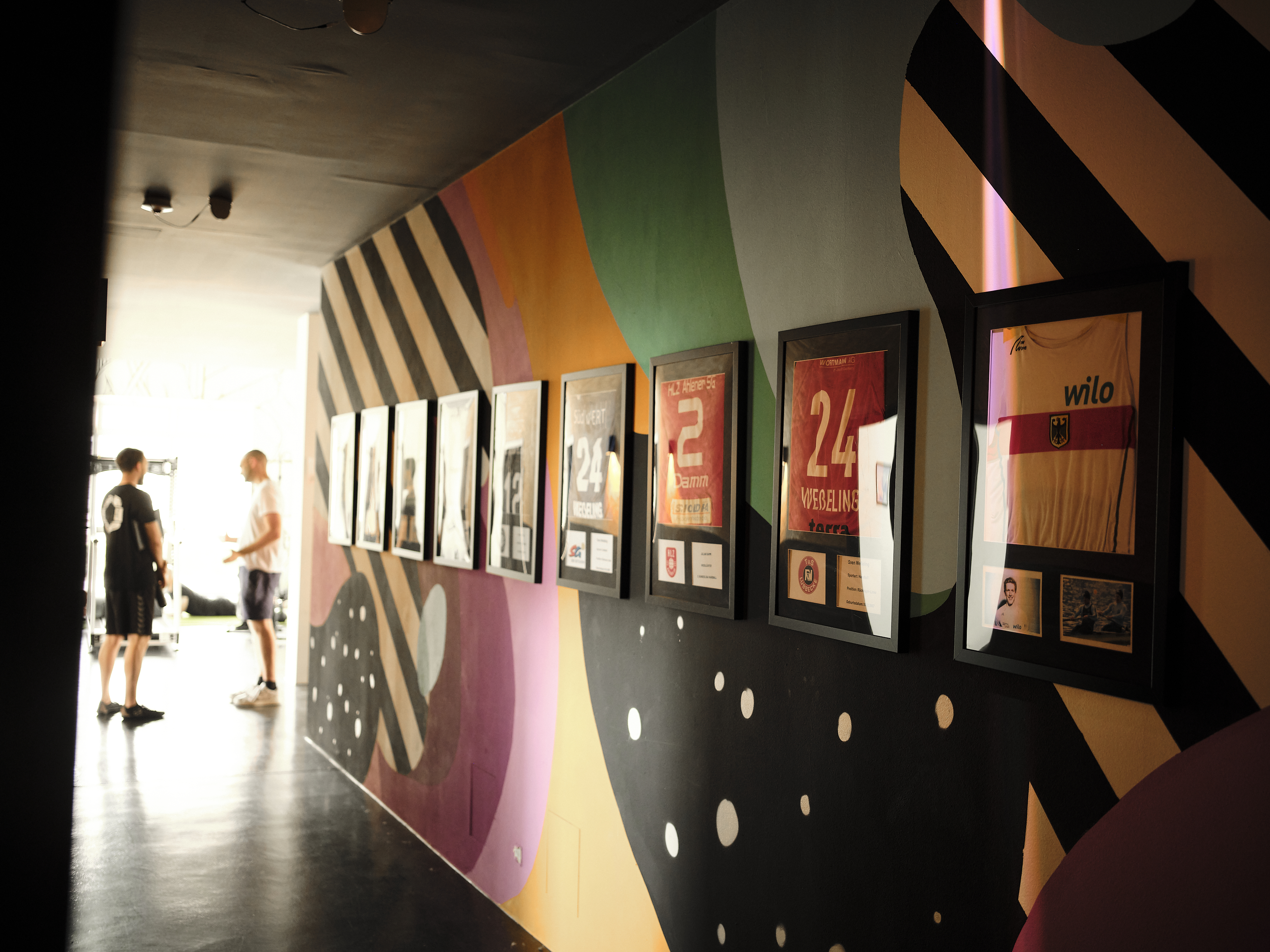 Gang mit gerahmten Sport-Trikots an der Wand