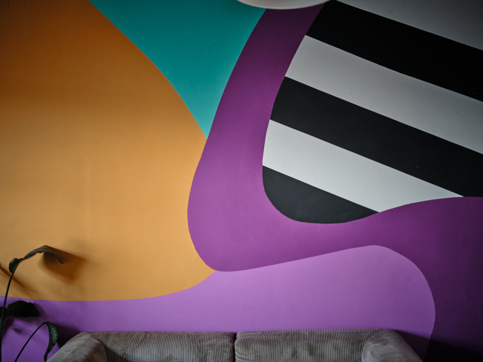 Wartebereich mit Sofa vor farbigem Mural